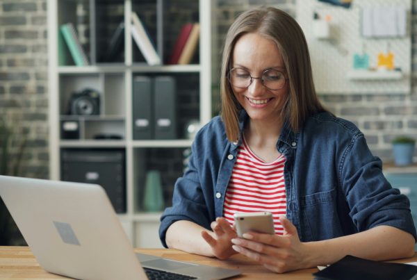 Woman at desk testing no-code application on mobile phone