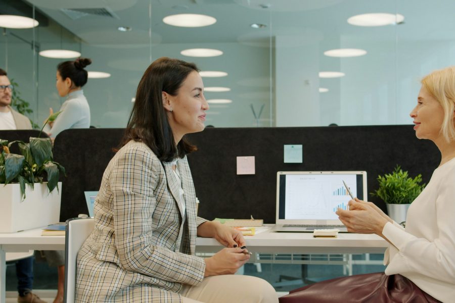 Two women in a small business use decision intelligence tool in a meeting to make the right choices